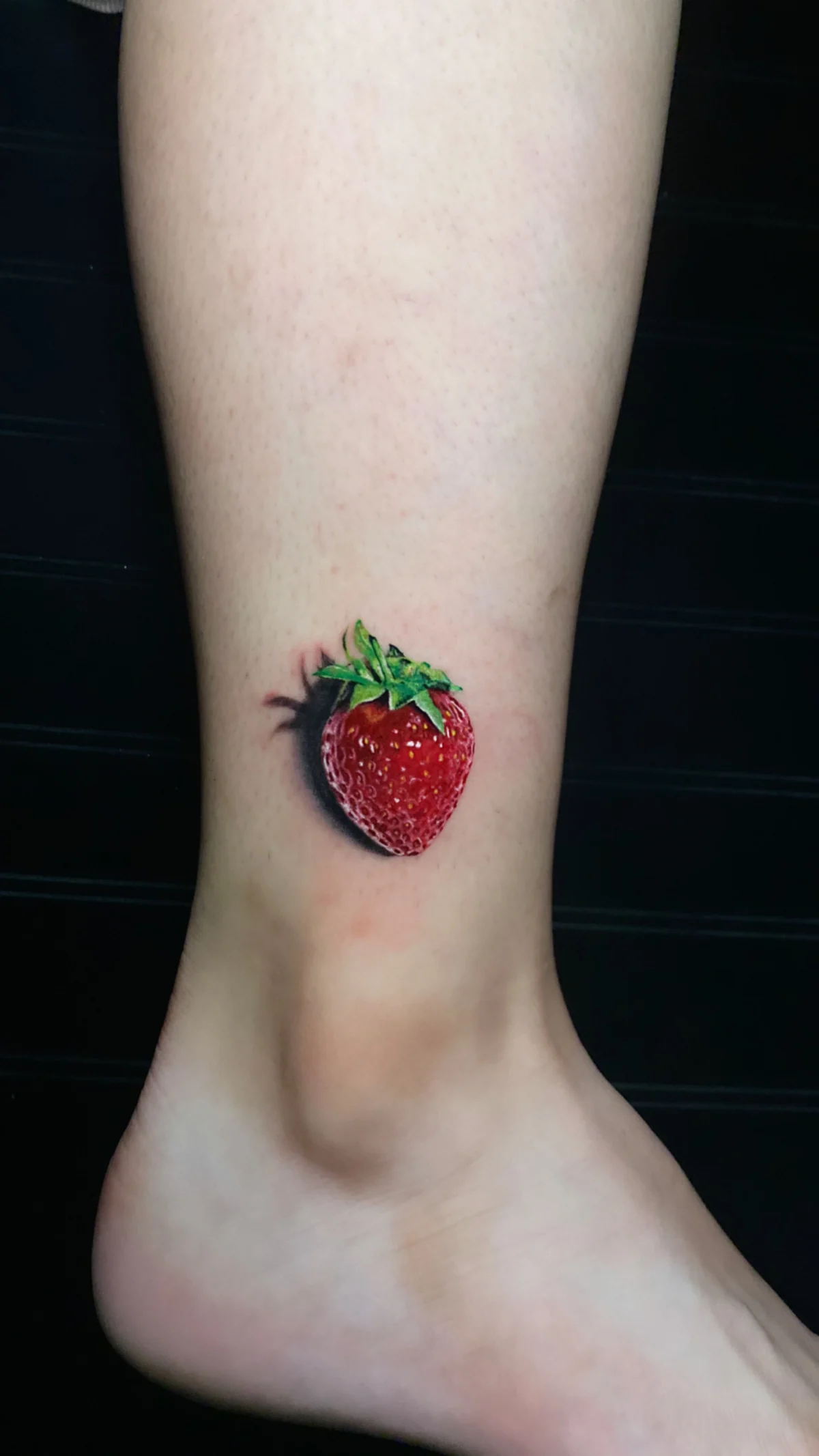 Hyperrealistic strawberry with a cast shadow on the ankle, by H