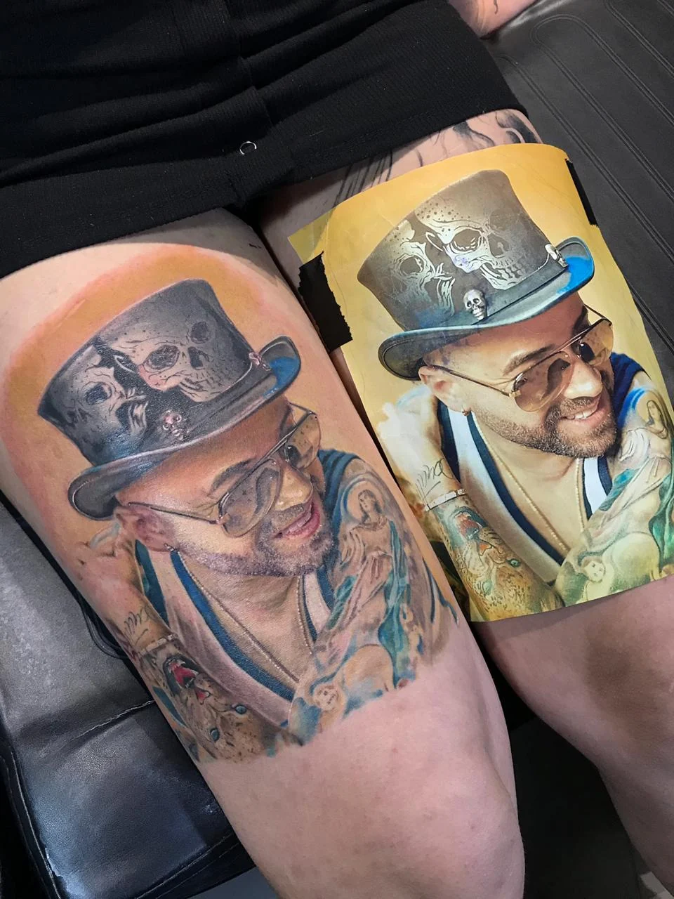 Colour realism portrait with a skull top hat on the thigh, shown beside the reference photo, by H